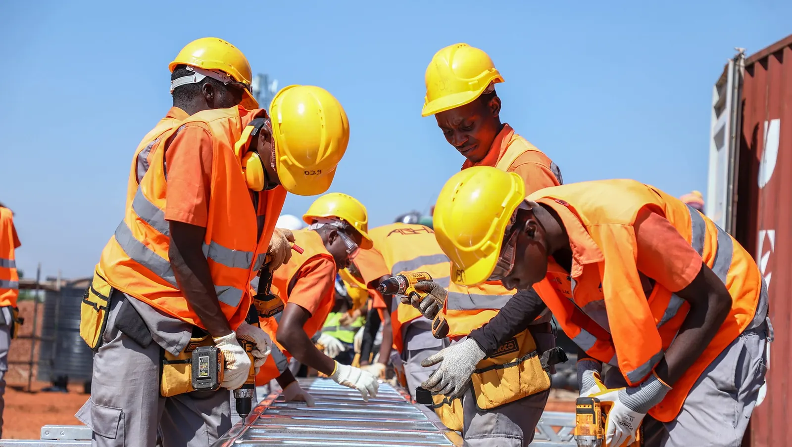 Equipe de obra com EPI em instalações e montagem de estrutura metálica
