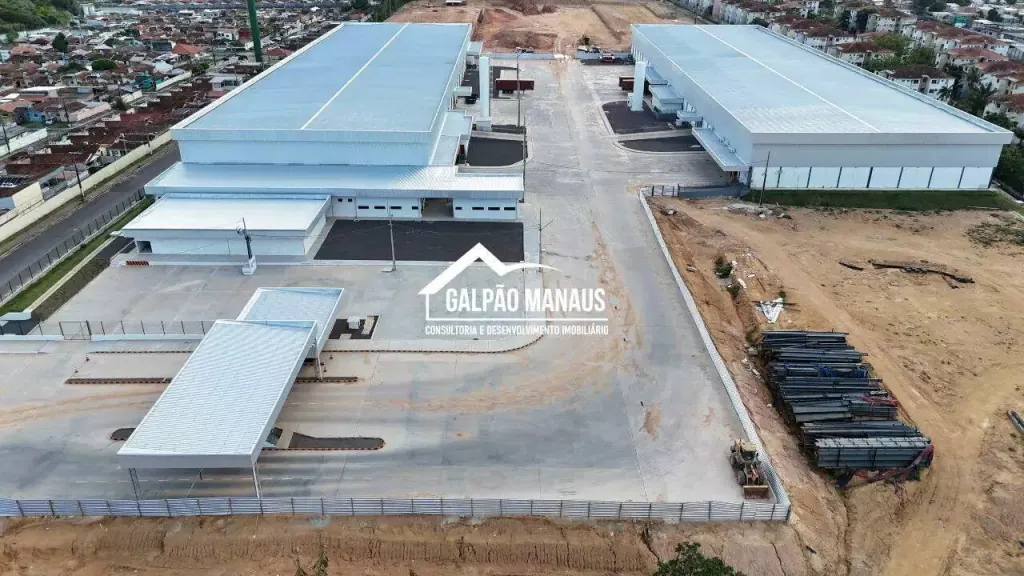 Vista aérea de dois galpões geminados com telhado curvo e pátio de manobra compartilhado