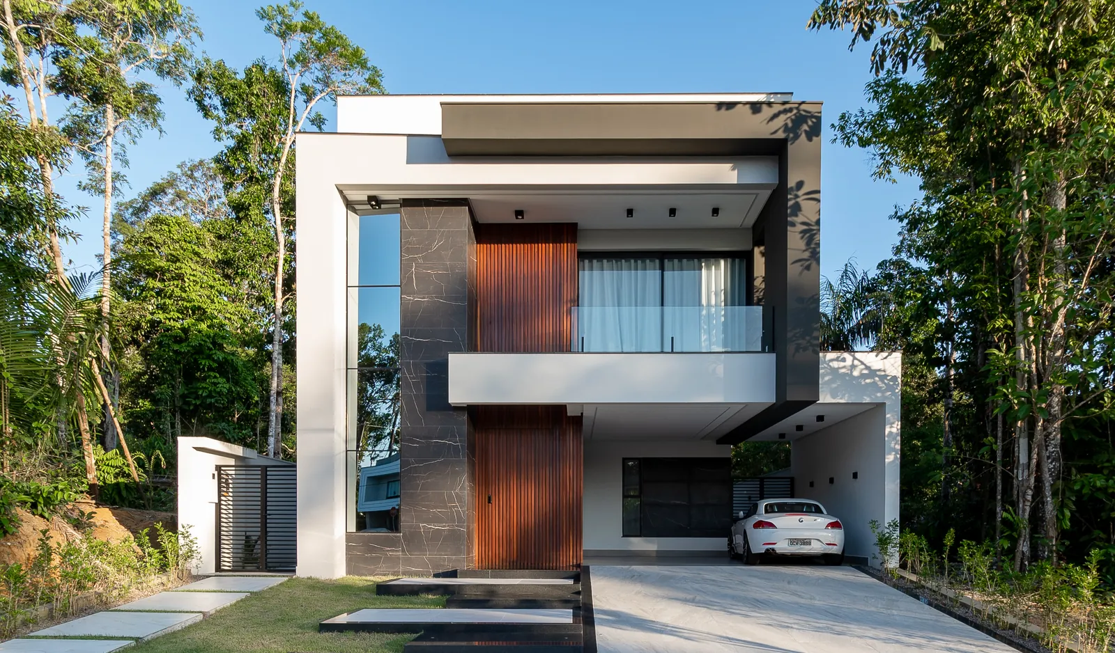 Fachada da Residência J|A com revestimento Nero Venato e madeira