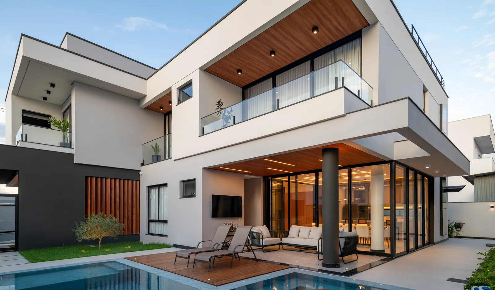 Área de lazer da Residência L|D: piscina, deck de madeira e varanda integrada